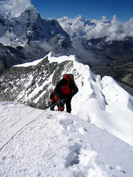Climber taking the final few steps onto the 20,305 ft. (6,189 m) summit of Imja Tse (Island Peak) in Nepal. Summitting Island Peak.jpg