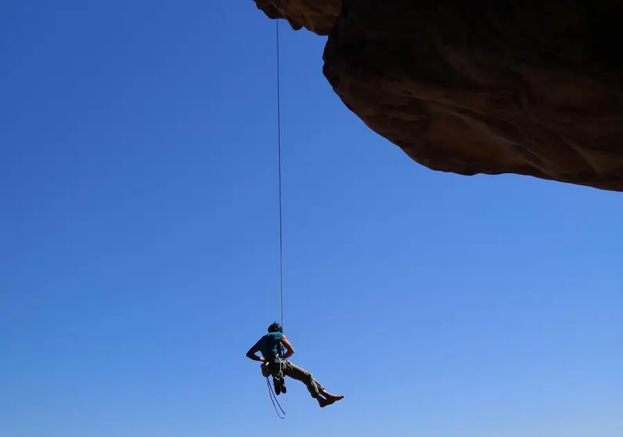 A coach shows a new climber the basics on the wall