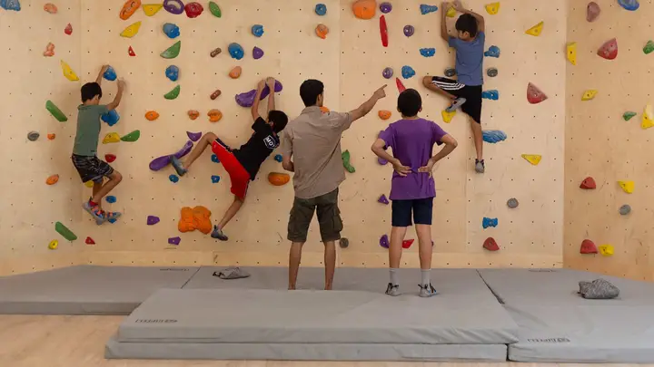 Kids climbing under Coach Viraj learning various movement patterns