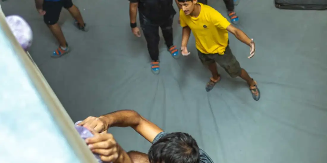 A BoulderBox coach teaching a group of new climbers