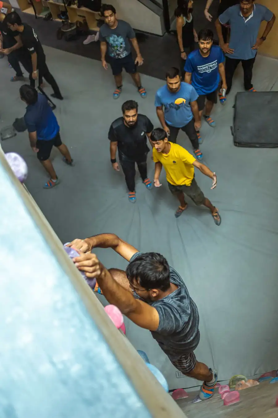 A BoulderBox coach teaches a group of new climbers